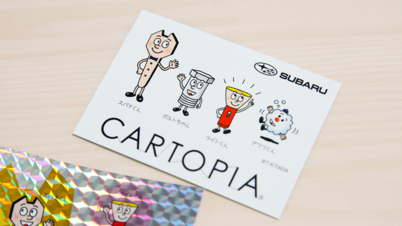 カートピア スパナくんファミリーが描かれている、カートピアオリジナルのステッカー。白い背景にキャラクターが並んでいる | SUBARU