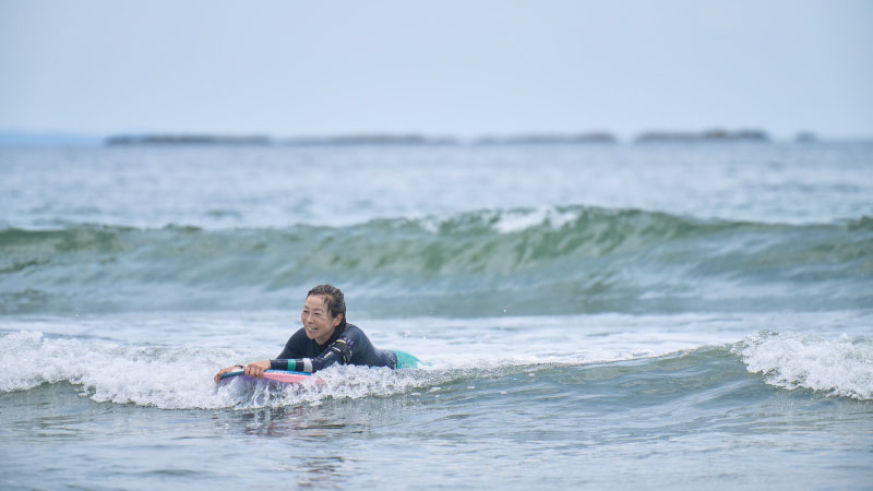 カートピア 波に乗って笑顔を浮かべる飯田裕子さん | SUBARU