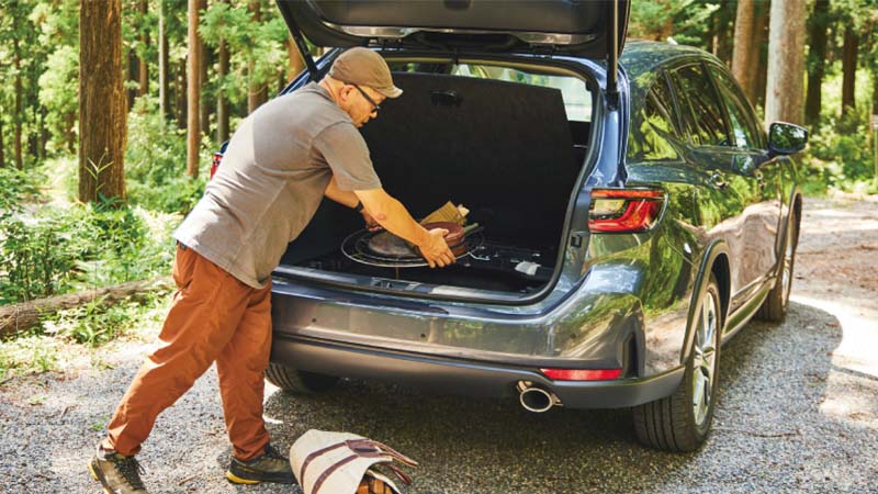 カートピア レヴォーグ レイバックのカーゴルームにキャンプ道具を積んでいる寒川さん | SUBARU