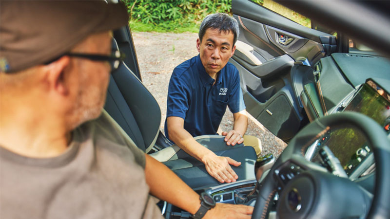 カートピア 運転席に座る寒川さんにシートについて説明する中野さん | SUBARU