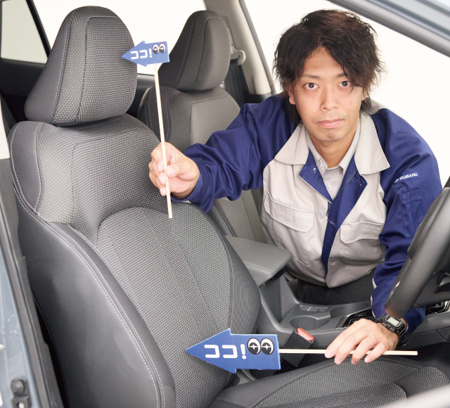 カートピア 矢動丸裕介さんが、両手に持ったココスバポインターで運転席の部分を指し示しています。左手のポインターでは下部背もたれの腰があたるあたり、右手のポインターではヘッドレストの上部あたりを指し示しています | SUBARU