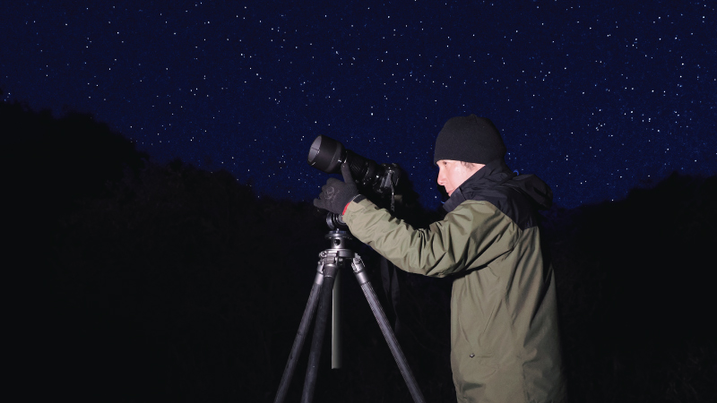 カートピア 星空の下、三脚に取り付けたカメラを構えるデジタルライターの湯浅顕人さん。 | SUBARU